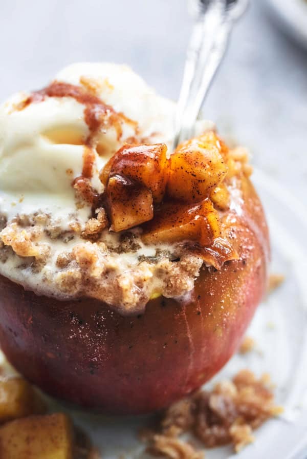 up close spoon digging into apple with filling and oat topping