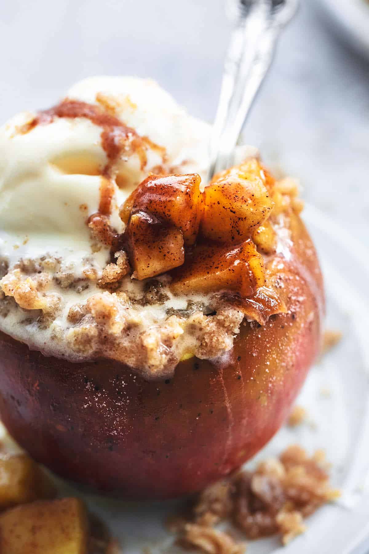 up close spoon digging into apple with filling and oat topping
