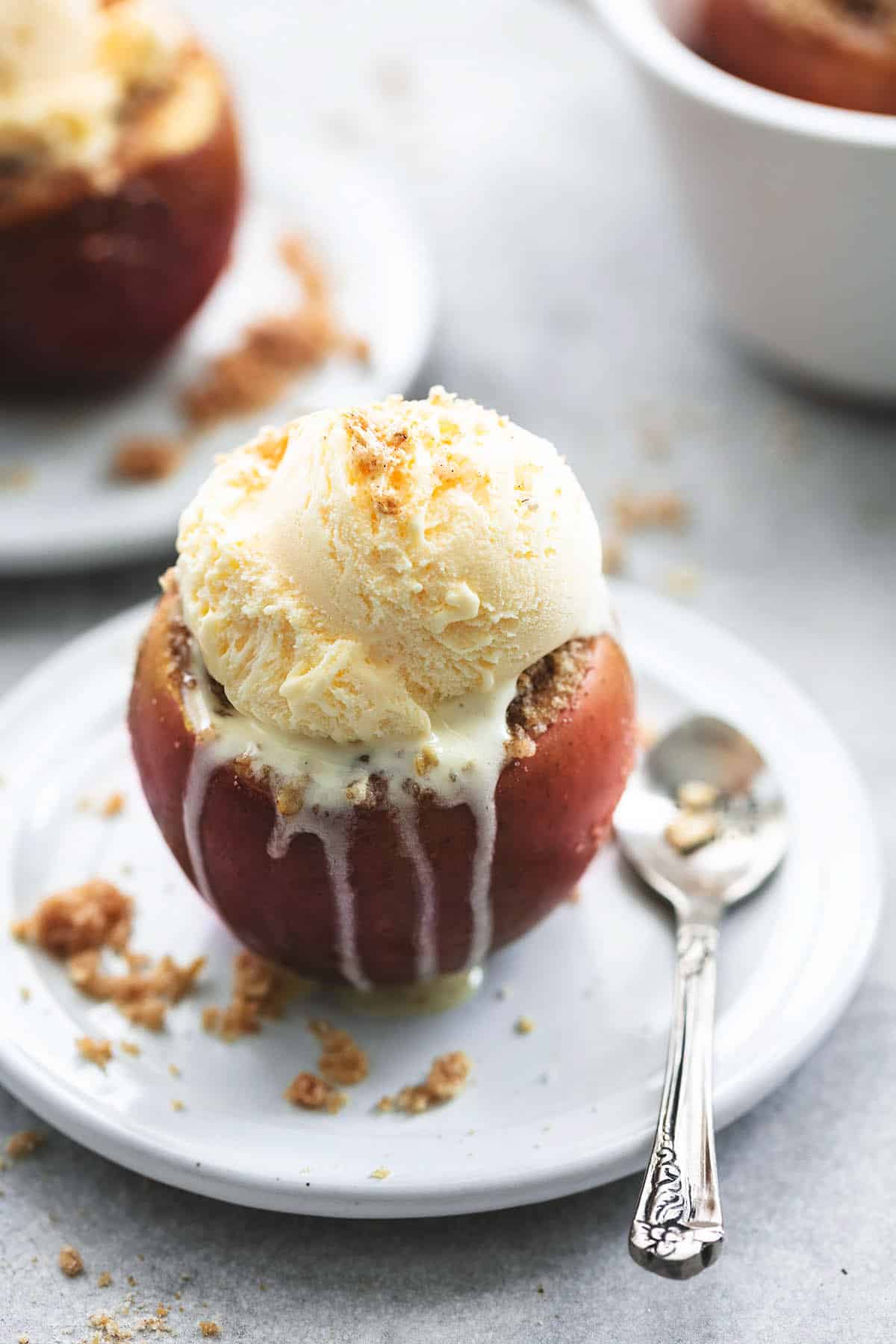ice cream on top of apple on plate with spoon