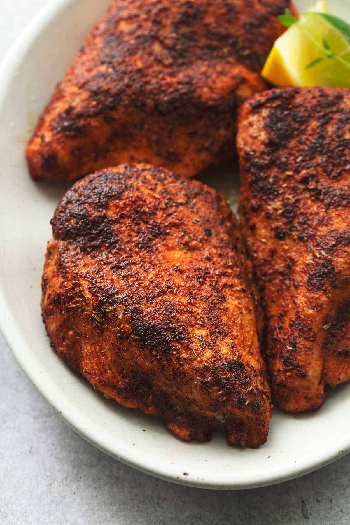 up close seasoned baked chicken on plate