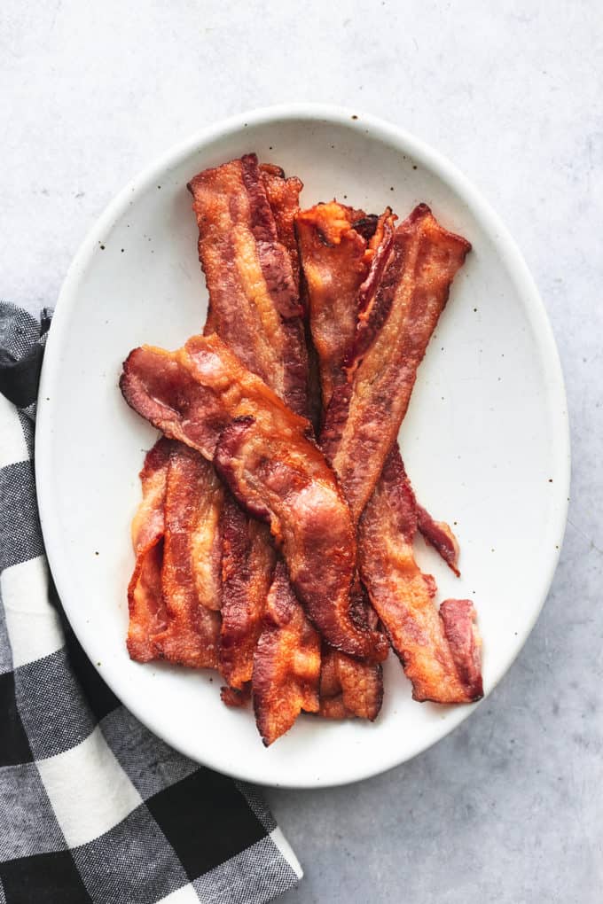 plate of bacon slices on table with cloth napkin