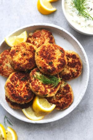 platter of crab cakes with lemon wedges and fresh dill