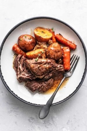 beef chunks with carrots and potatoes with gravy on plate with fork