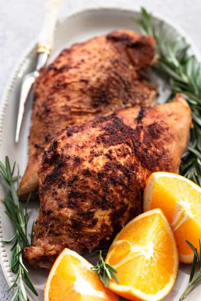cooked turkey breast on platter with rosemary