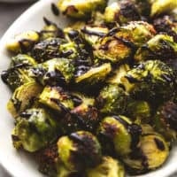 cooked brussels sprouts on platter with balsamic reduction drizzle