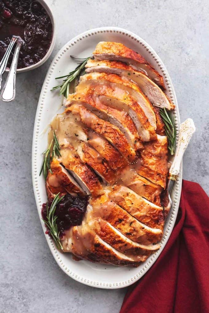 overhead roasted turkey on platter with cranberry sauce in bowl