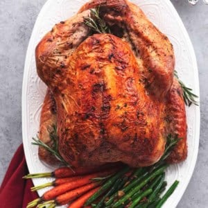 whole roasted turkey on platter with vegetables