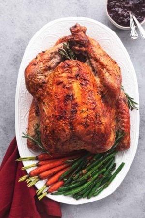 whole roasted turkey on platter with vegetables