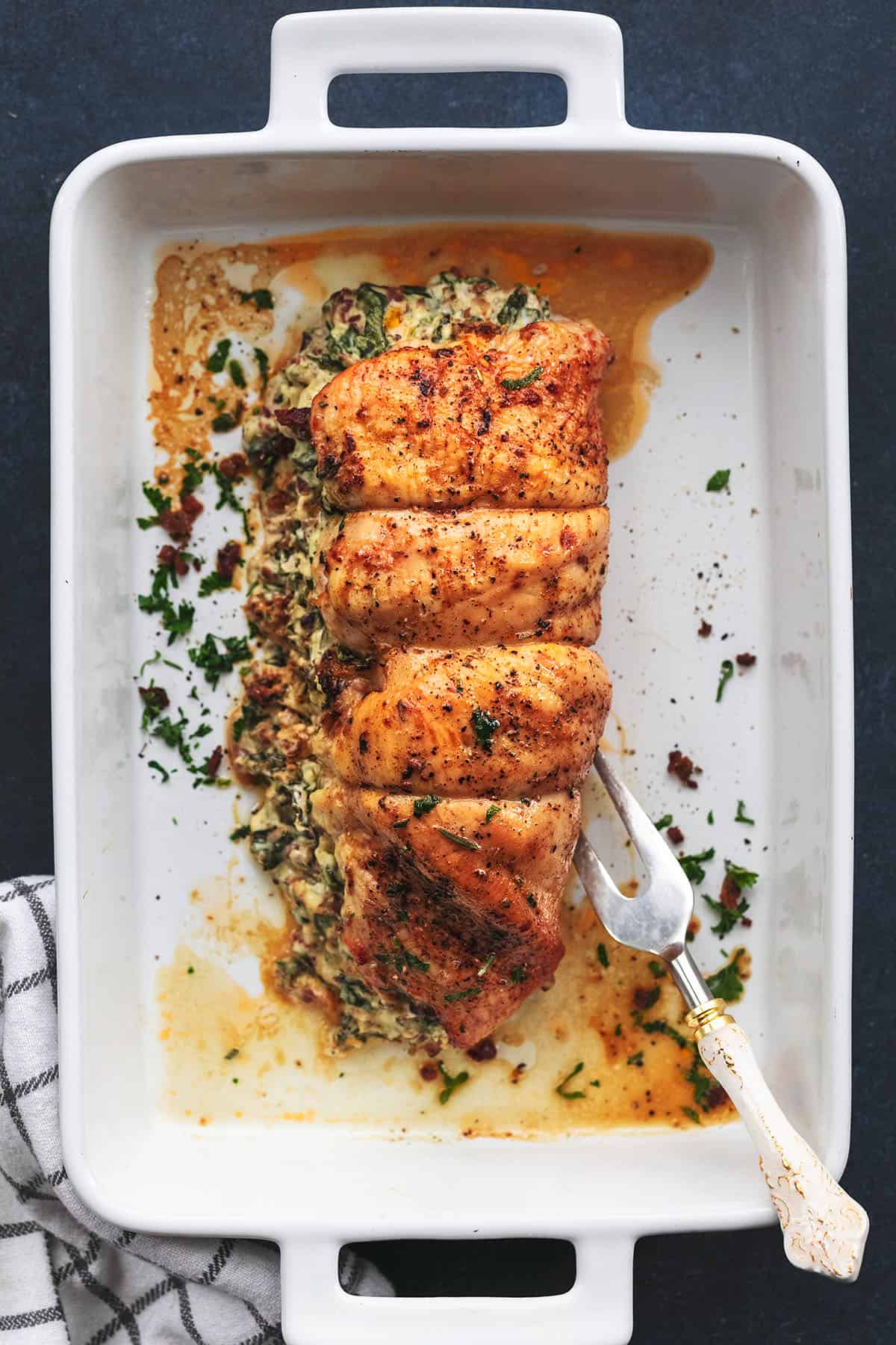 roasted turkey tenderloin with bacon and spinach filling in a baking pan