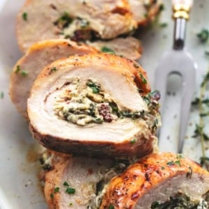 up close single slice of stuffed turkey breast atop more pieces on a plate