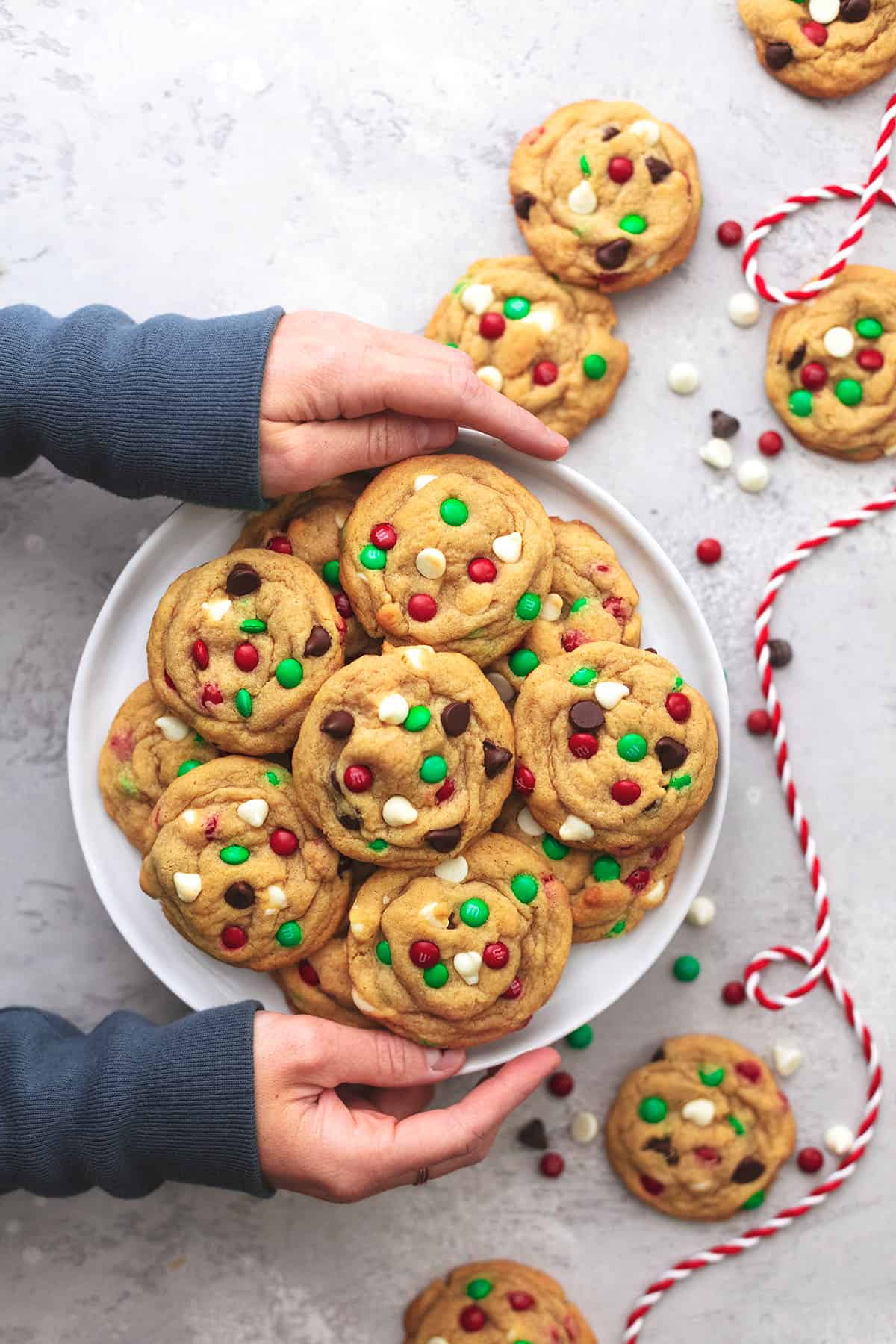 hands holding platter of christmas cookies