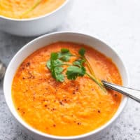 bowl of carrot soup with fresh cilantro garnish and spoon