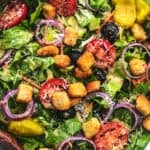 bowl of salad with serving spoons