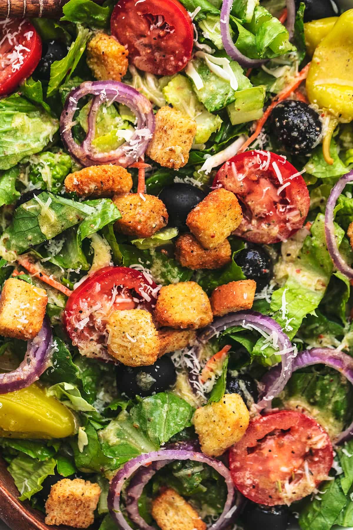 up close view of salad with croutons, tomatoes, onions, and olives