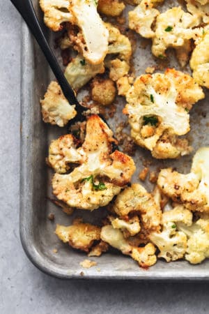 roasted cauliflower on a baking sheet with a serving fork