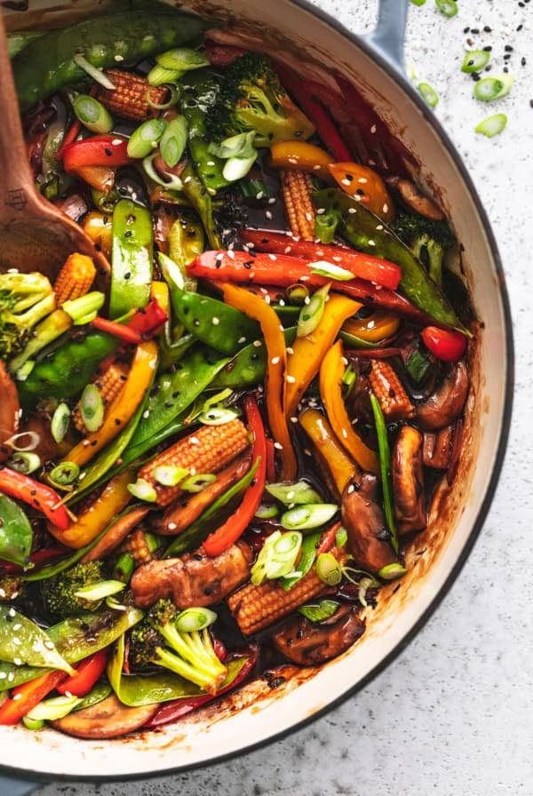 overhead view of half of a skillet full of cooked veggies in asian stir fry sauce