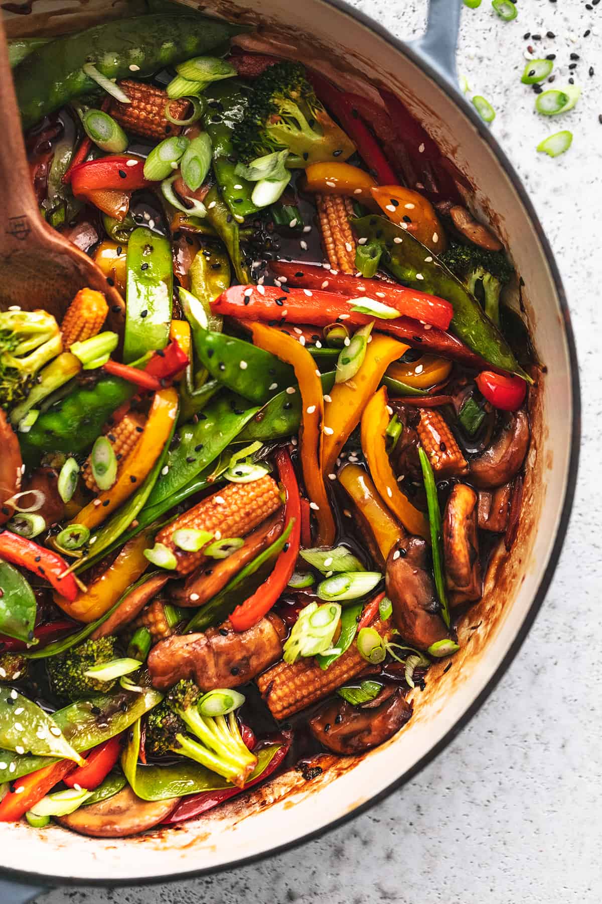 overhead view of half of a skillet full of cooked veggies in asian stir fry sauce