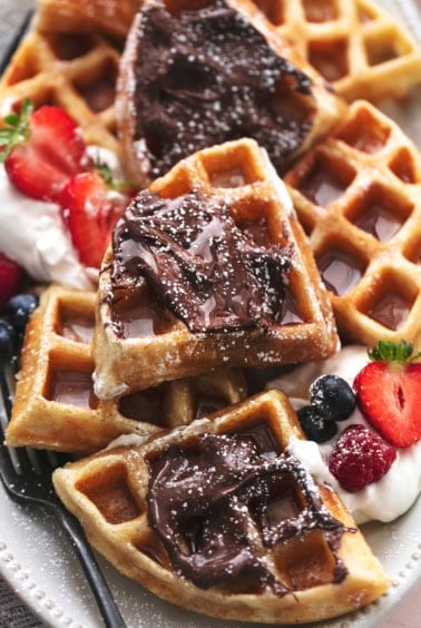 up close view of quartered waffles on a platter with toppings