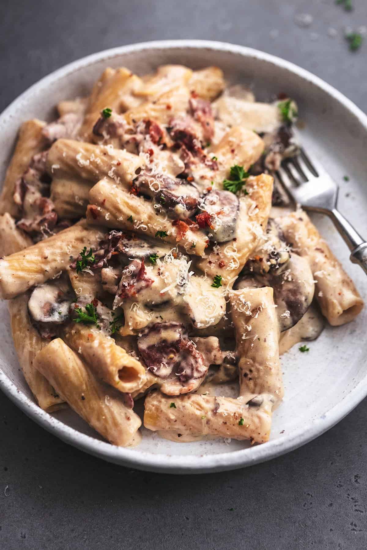 close up view of rigatoni pasta with mushroom and bacon sauce