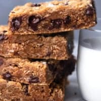 stack of cookie bars leaning against side of milk glass