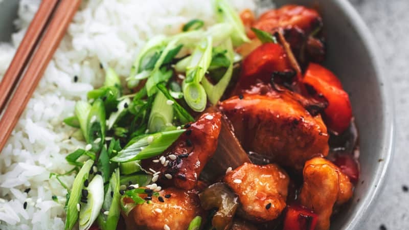 chinese chicken with veggies and rice in a bowl