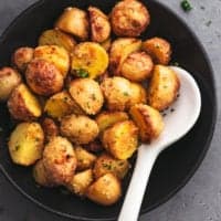 bowl full of crispy potatoes with serving spoon