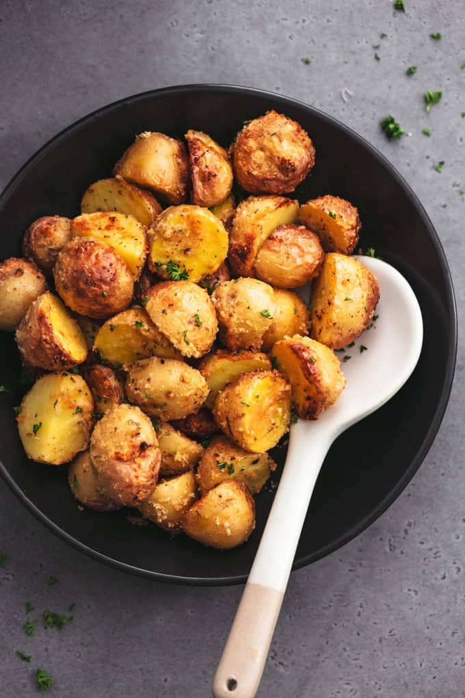 bowl full of crispy potatoes with serving spoon