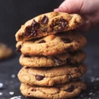 small hand lifting the top cookie from a stack of more cookies