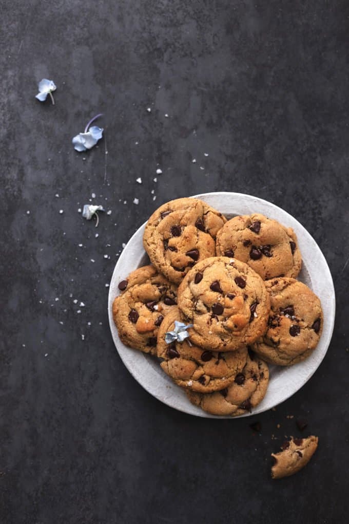 plate of cookies on a dark surface with a few small flowers scattered
