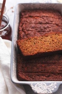 single slice of carrot cake bread on top of more slices in a loaf pan