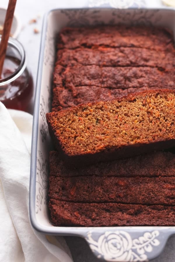 single slice of carrot cake bread on top of more slices in a loaf pan