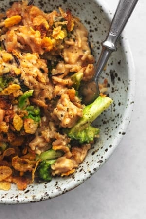 fork digging into bowl of chicken and rice with broccoli and cheese