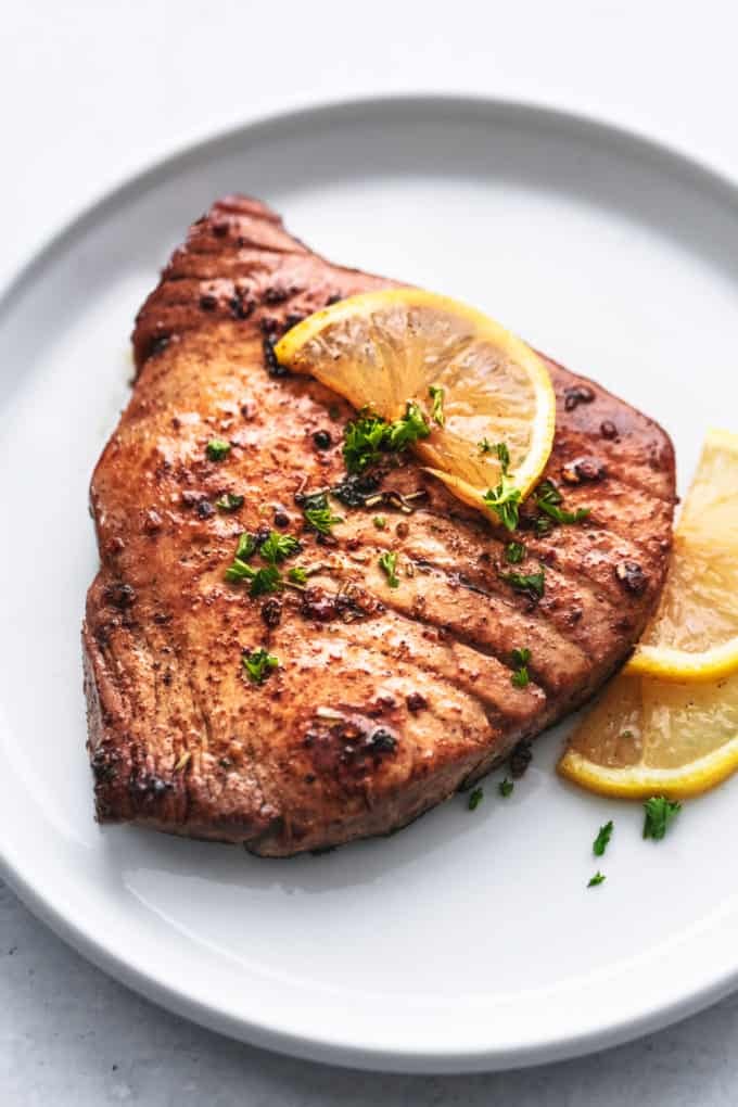 grilled tuna steak on a plate with lemon slices