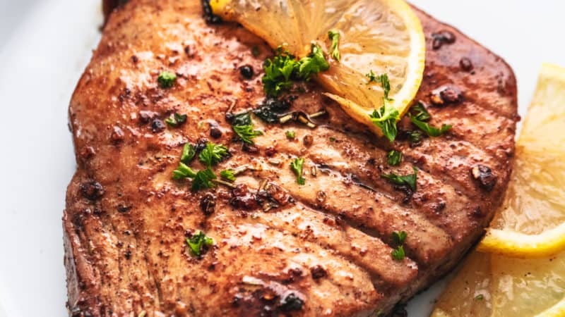 grilled tuna steak on a plate with lemon slices