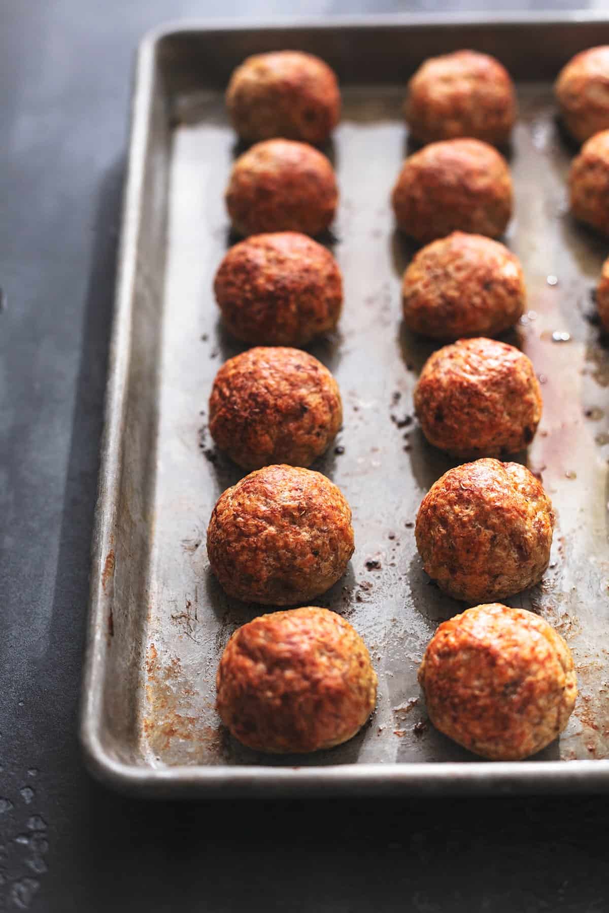 two rows of chicken meatballs on a pan