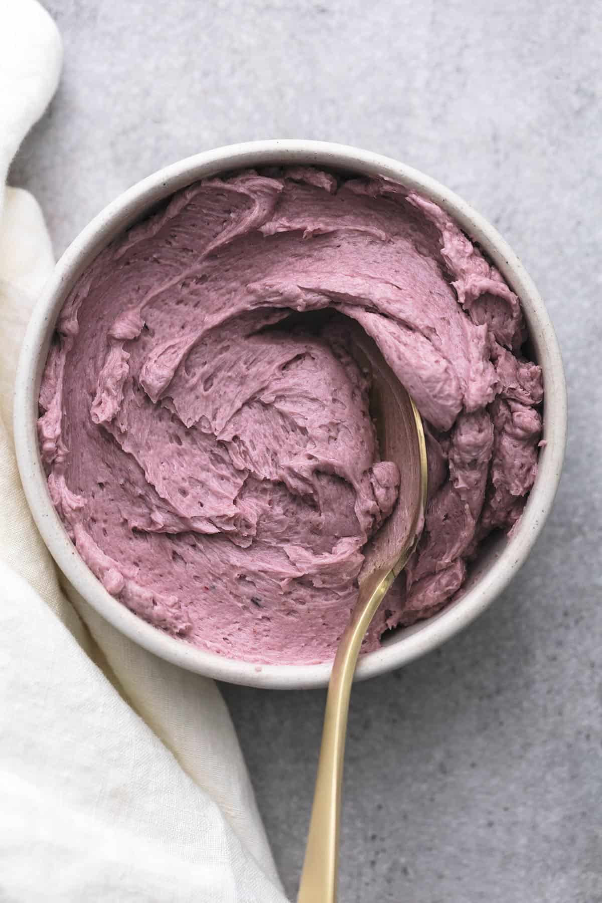 purple frosting in a bowl with a spoon