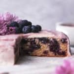 blueberry cake on marble cake stand with flowers and blueberries