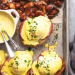 eggs benedict with hollandaise sauce and potatoes on a sheet pan