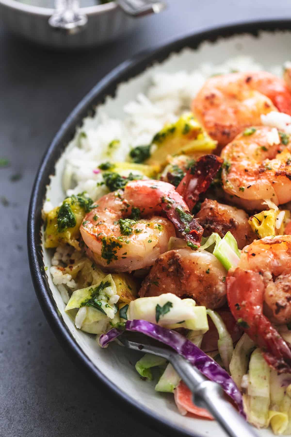 up close view of grilled shrimp with slaw and herb sauce