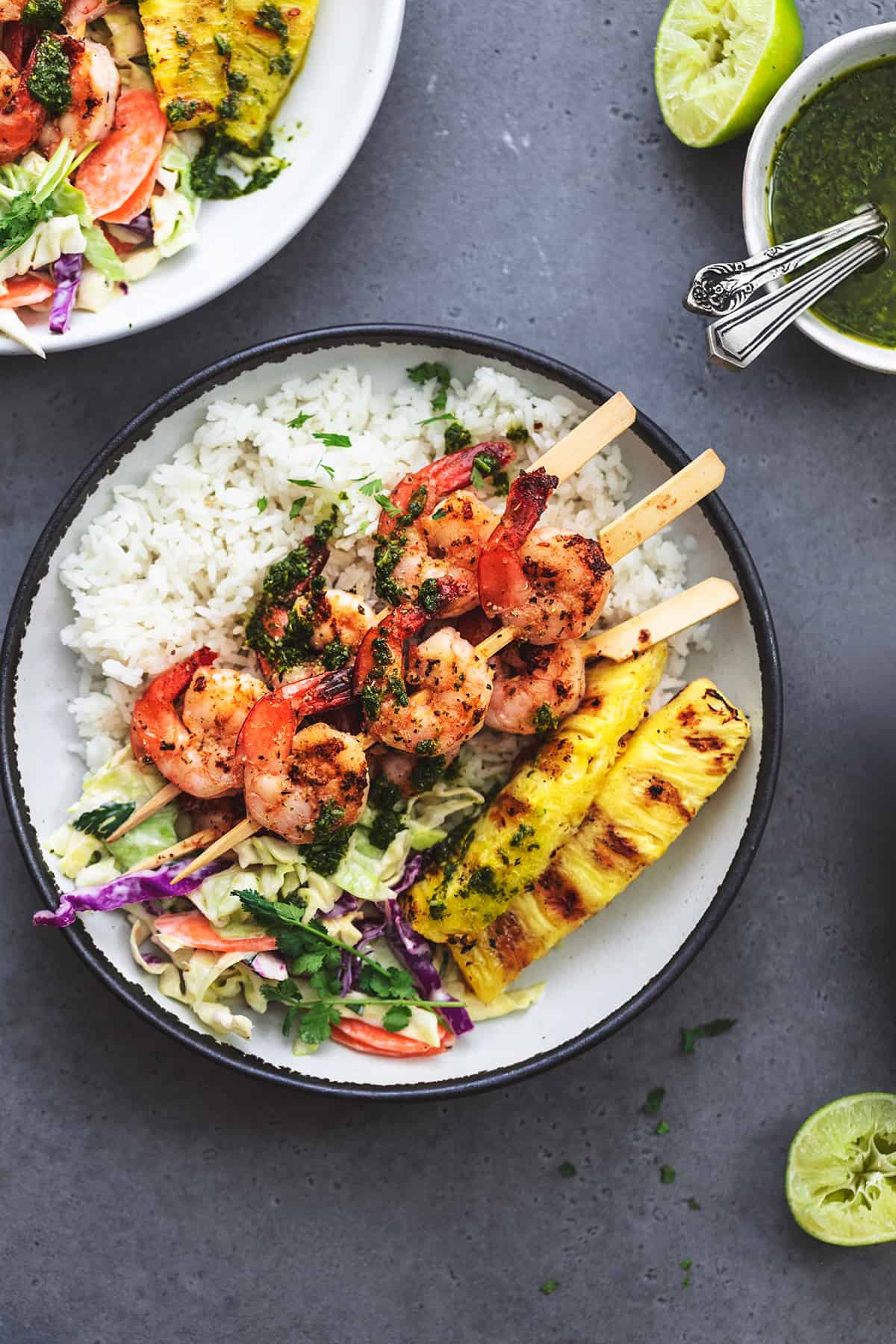 two plates of shrimp and rice and grilled pineapple