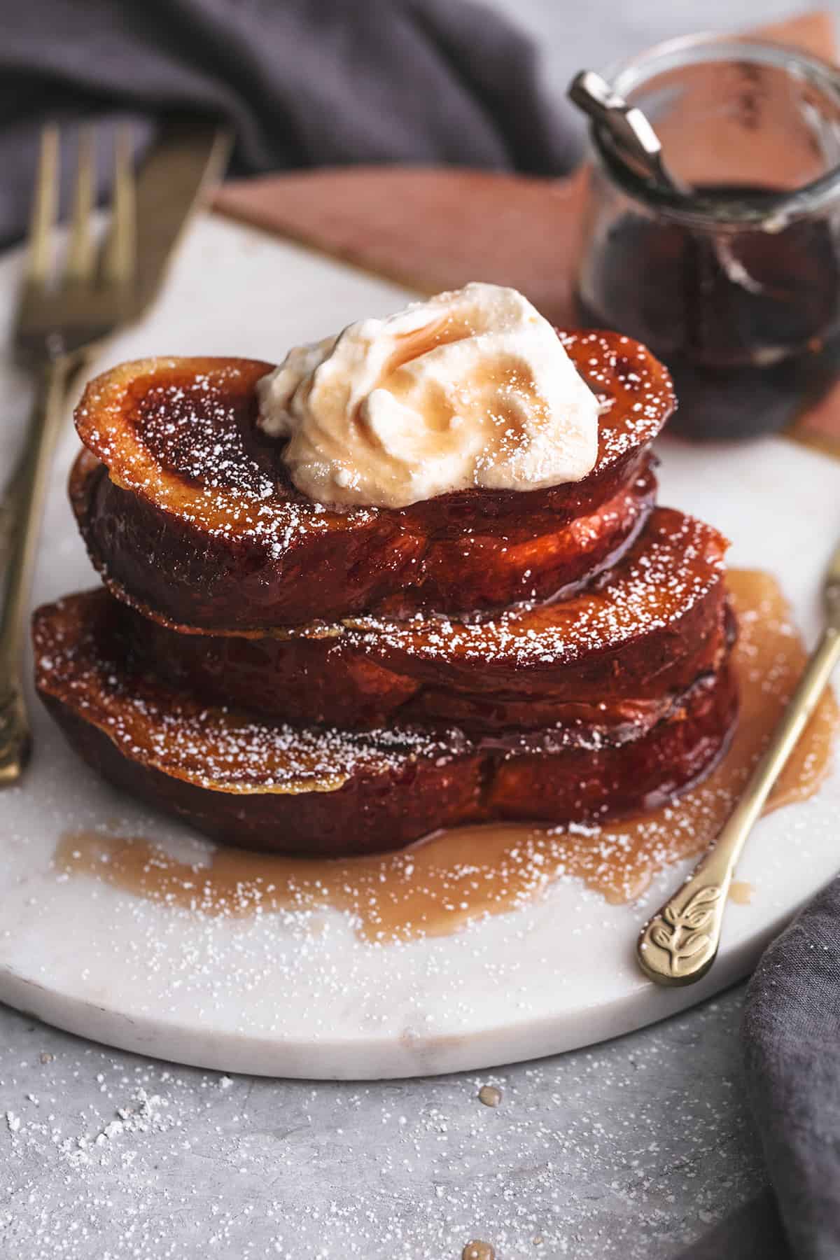 stack of french toast with syrup and whipped cream on top