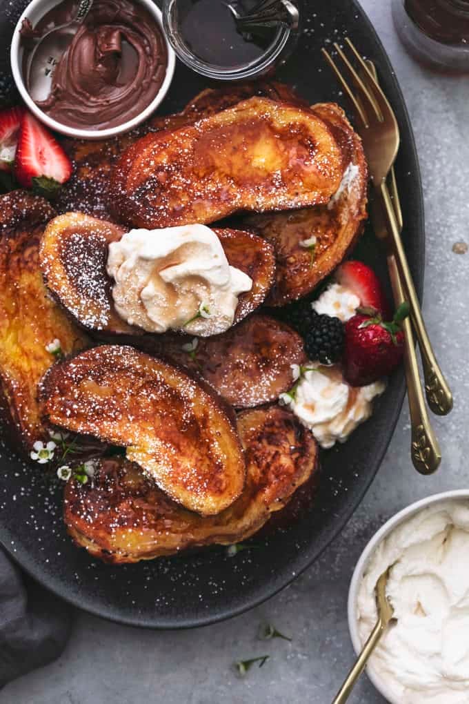 french toast with whipped cream and syrup on serving platter