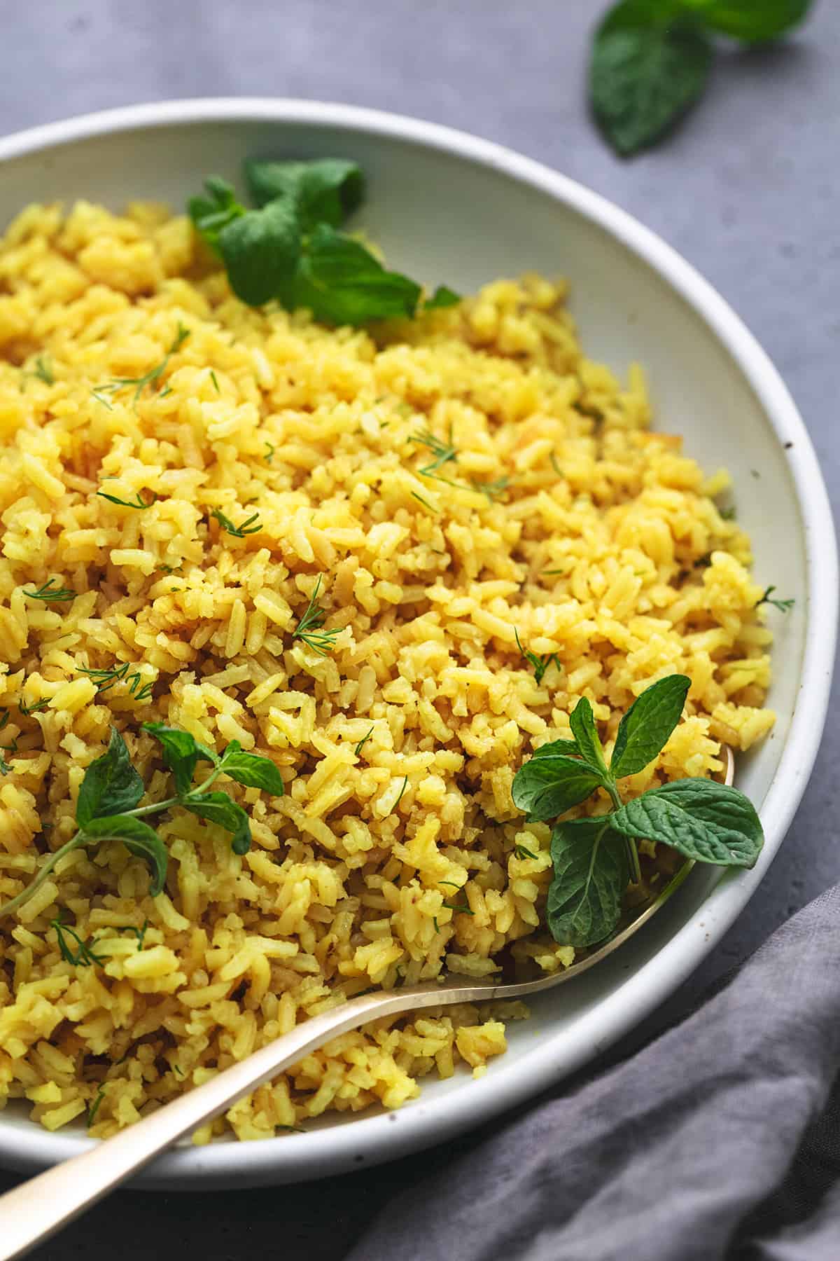 up close view of rice with fresh mint leaves in a bowl