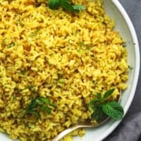 lemon rice with fresh herbs in a bowl with a spoon