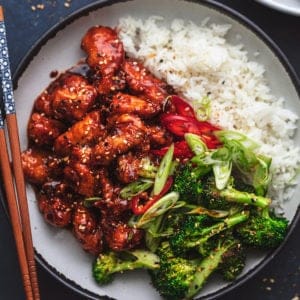 plate of korean fried chicken with broccoli and rice