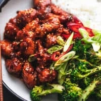 roasted broccoli and crispy saucy chicken pieces on plate