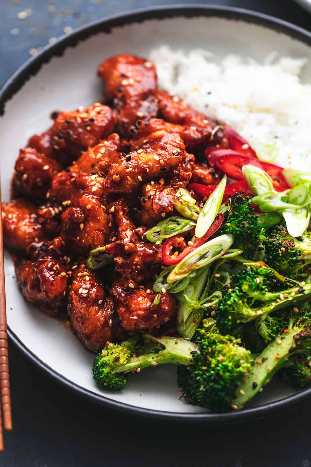 roasted broccoli and crispy saucy chicken pieces on plate