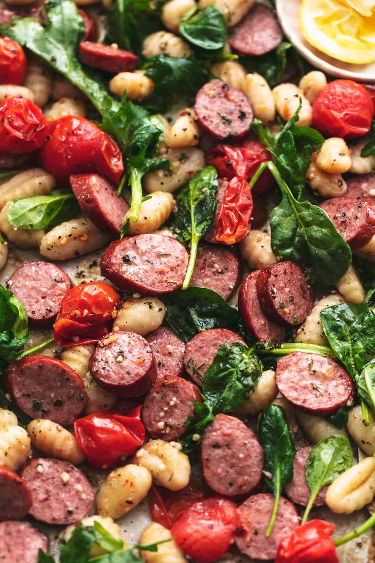 roasted kielbasa sausages with spinach and tomatoes and gnocchi