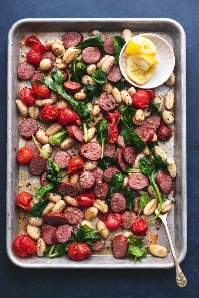sheet pan with gnocchi and sausage and lemon wedges