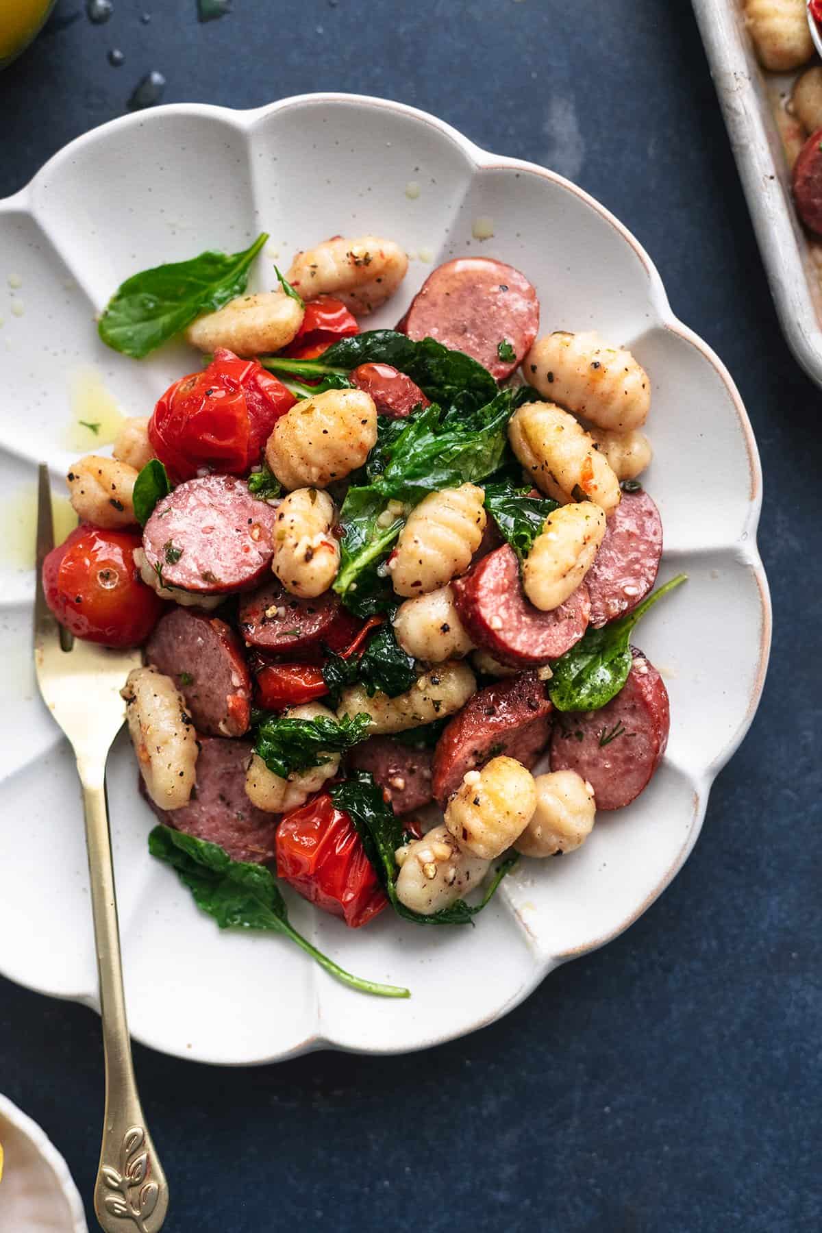 plate of gnocchi with sausage and spinach and tomatoes